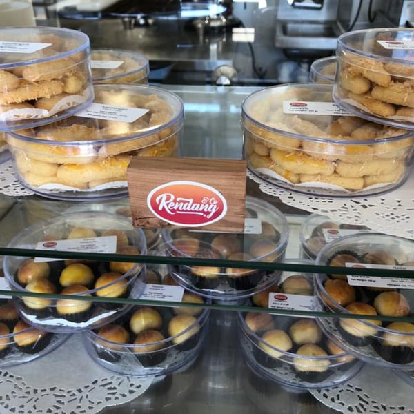 Indonesian pastries, including pineapple tarts and cheese cookies, displayed in clear containers at Rendang & Co.