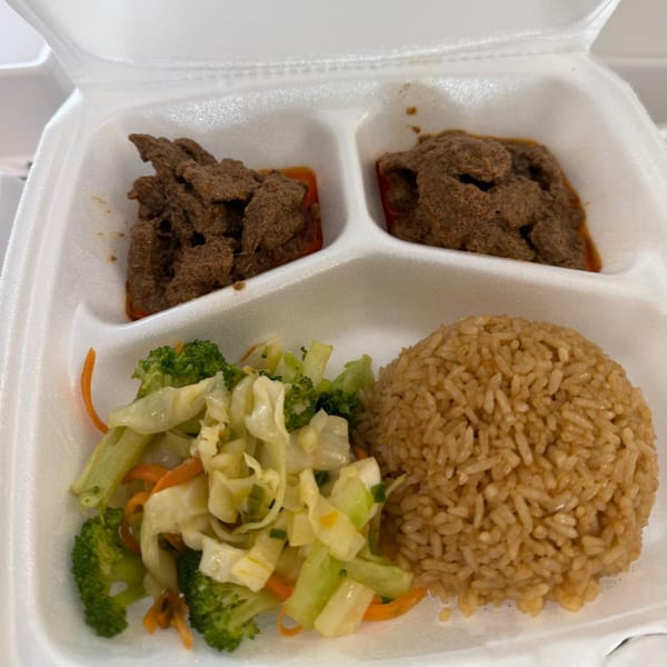 Indonesian Rendang & Co. takeout meal with beef rendang, rice, and mixed vegetables in a styrofoam container.